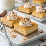 Pumpkin Cheesecake Bars served with whipped cream and cinnamon