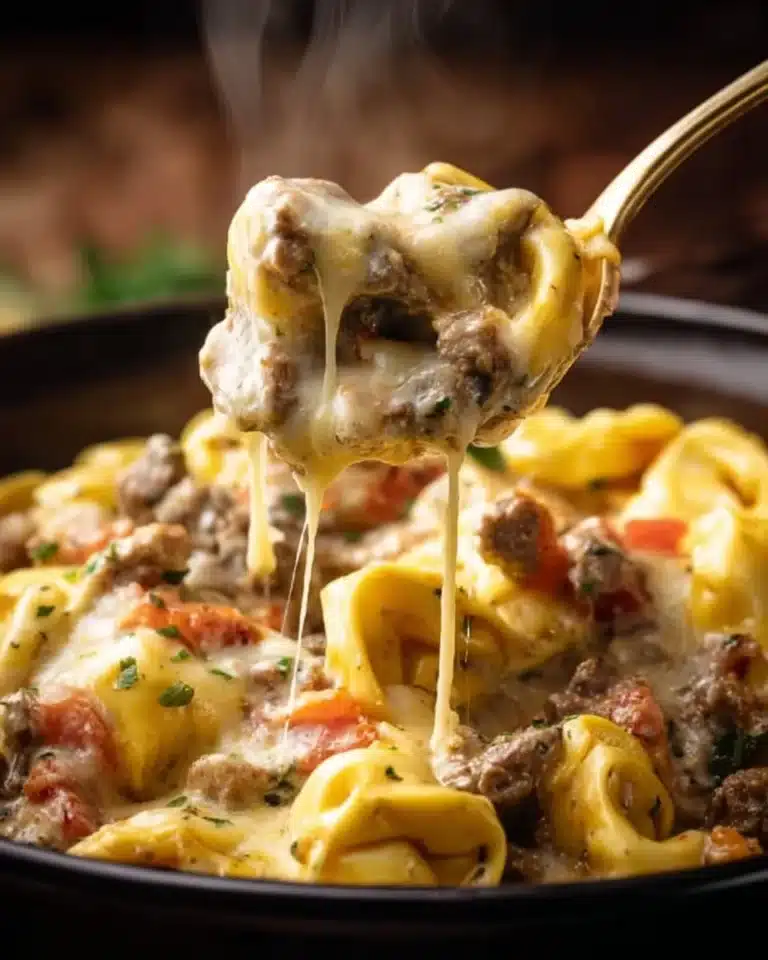 Delicious crock pot cheesesteak tortellini in a bowl with parsley garnish.