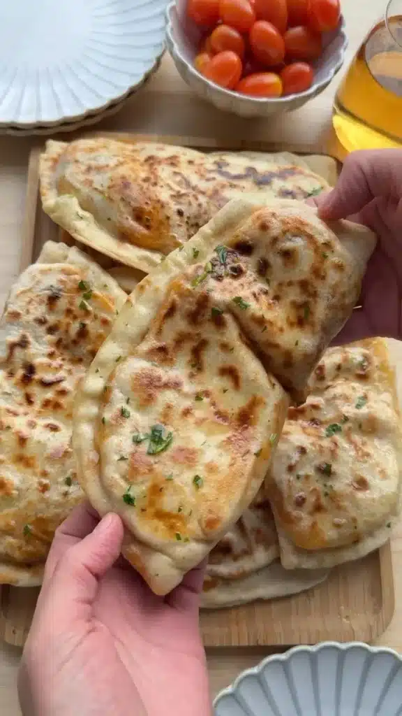 Flatbread topped with rich butter chicken, garnished for a delightful meal
