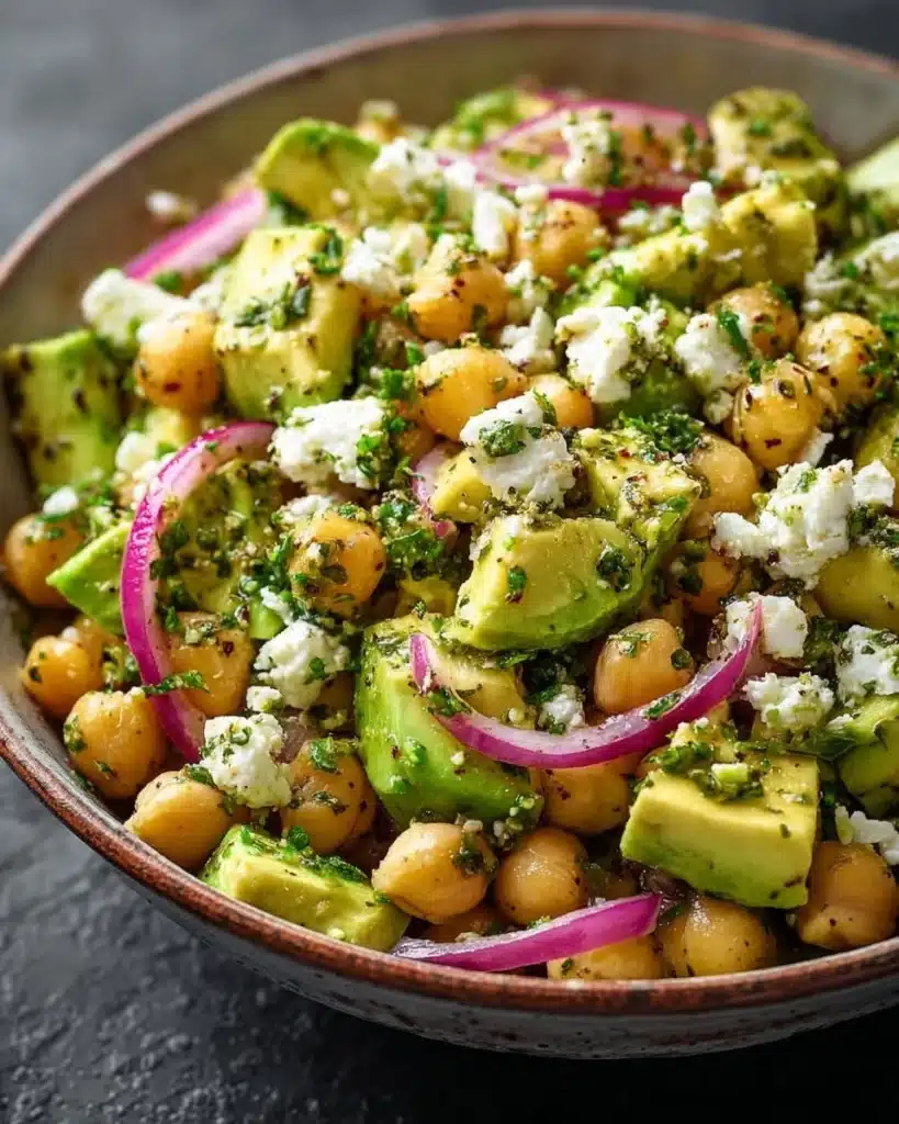 Chickpea Feta Avocado Salad in a bowl with fresh vegetables and dressing