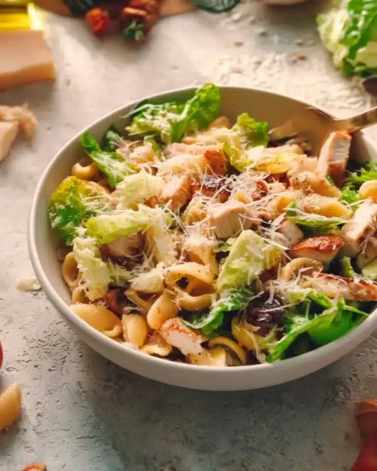 Pasta salad with chicken, parmesan cheese, and fresh vegetables in a bowl